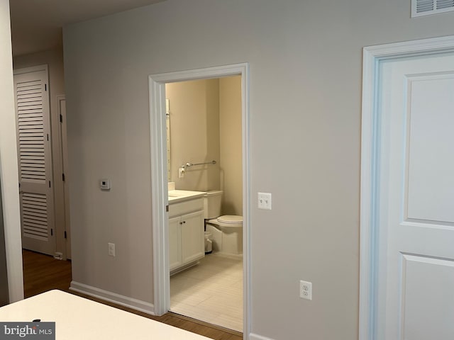 bathroom with vanity, hardwood / wood-style floors, and toilet