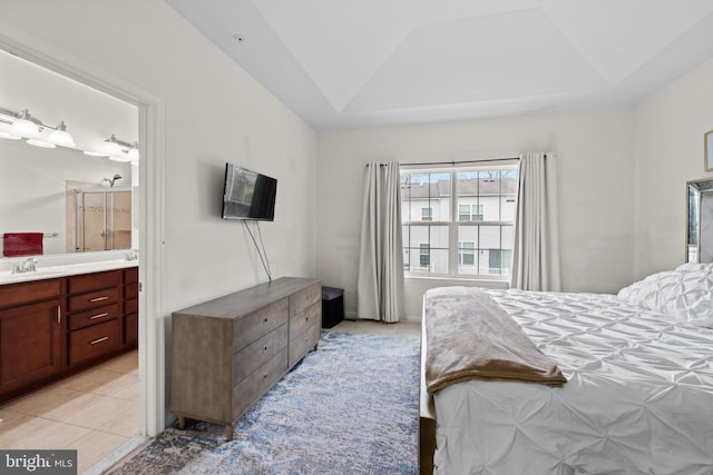 tiled bedroom with connected bathroom, sink, and vaulted ceiling