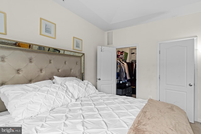 bedroom featuring a closet, light carpet, and a walk in closet