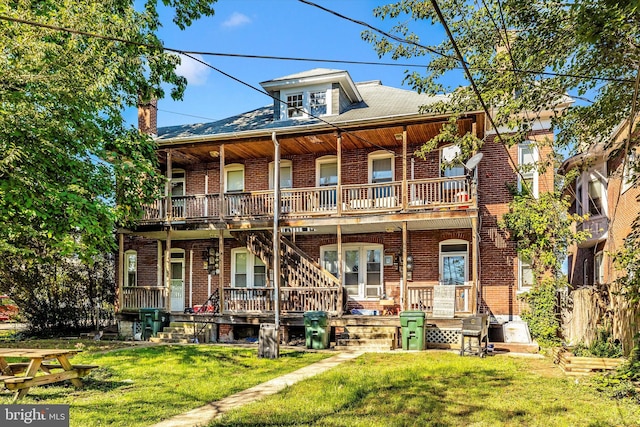 view of front of home featuring a front yard and a balcony