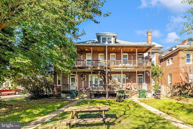 back of house with a yard, a porch, and a balcony