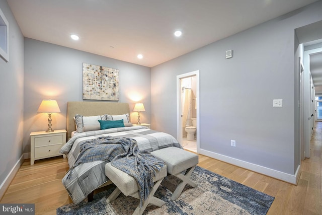 bedroom featuring light wood-type flooring and ensuite bath