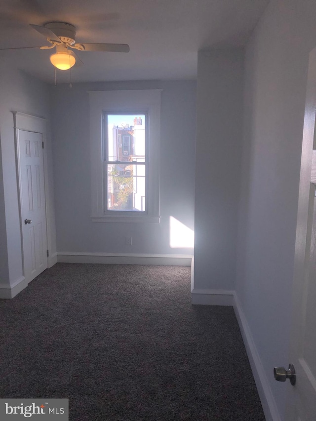 carpeted spare room featuring ceiling fan