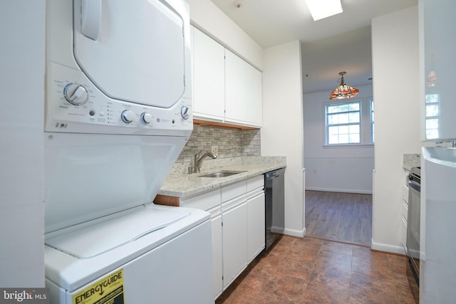 washroom with stacked washer / dryer and sink