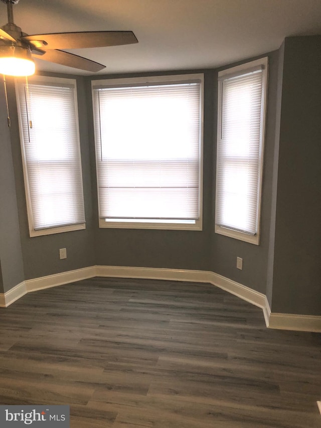 unfurnished room with dark hardwood / wood-style floors and ceiling fan