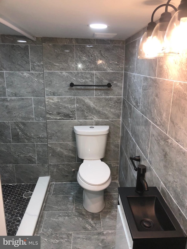 bathroom with sink, toilet, tile walls, and walk in shower