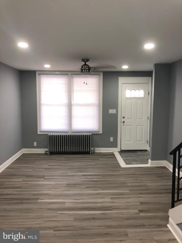 foyer entrance featuring radiator and dark hardwood / wood-style flooring