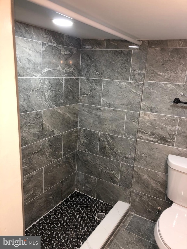 bathroom featuring toilet and tiled shower