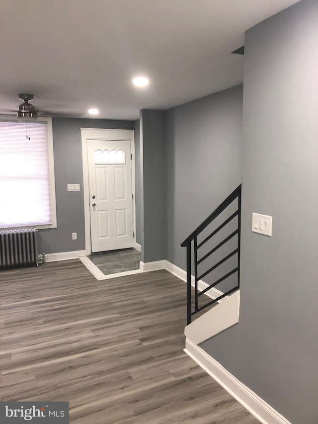 entryway with dark hardwood / wood-style flooring, radiator, and ceiling fan