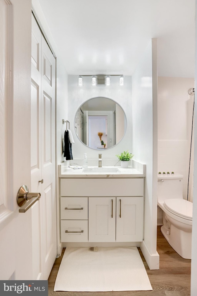 bathroom featuring hardwood / wood-style floors, vanity, and toilet