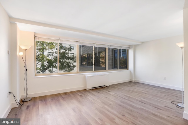 unfurnished room with light wood-type flooring and radiator