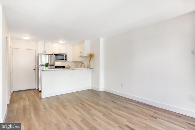 kitchen featuring light hardwood / wood-style floors, stainless steel appliances, and white cabinets