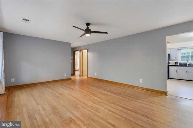 interior space with ceiling fan, sink, and light hardwood / wood-style floors