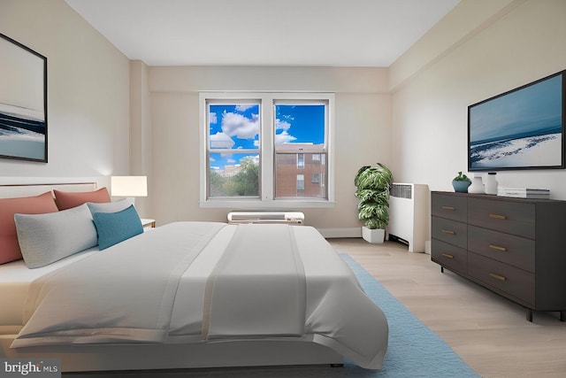 bedroom with radiator heating unit and light hardwood / wood-style floors