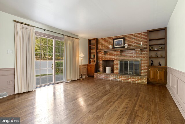 unfurnished living room featuring a fireplace, built in features, and dark hardwood / wood-style floors