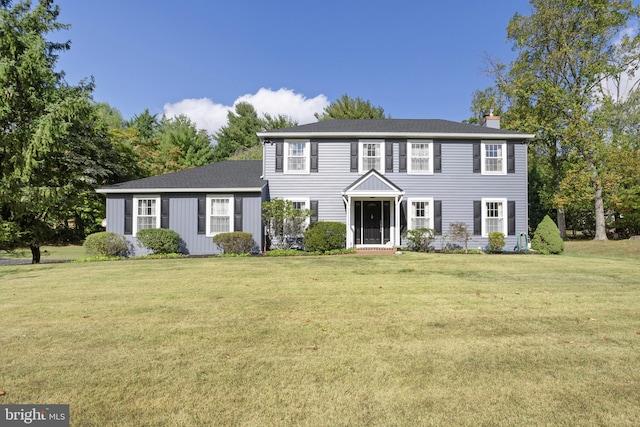 colonial inspired home with a front lawn