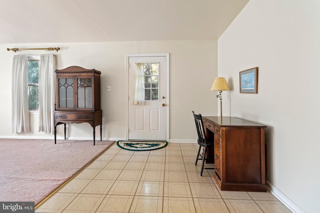 foyer with a healthy amount of sunlight and light colored carpet