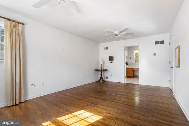 unfurnished room with ceiling fan, a wealth of natural light, and wood-type flooring