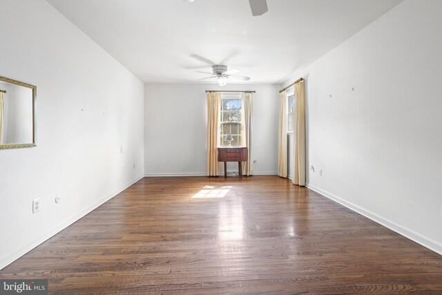 empty room with ceiling fan and dark hardwood / wood-style flooring