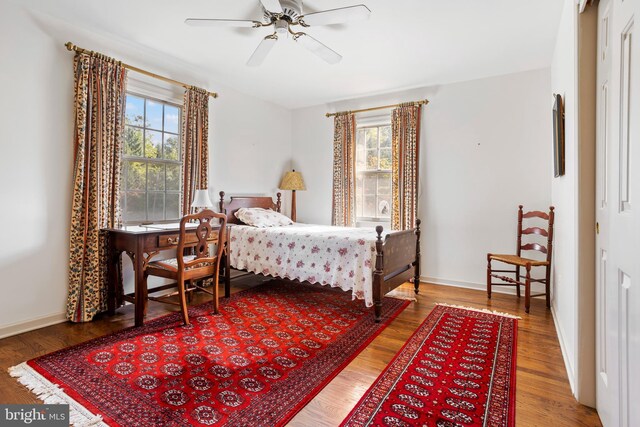 bedroom featuring hardwood / wood-style flooring, multiple windows, and ceiling fan