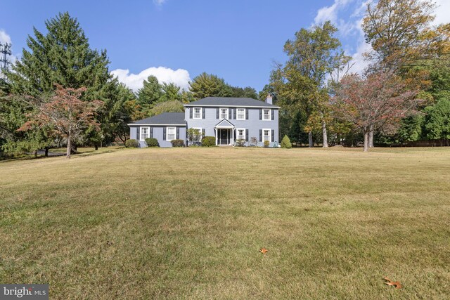 colonial inspired home featuring a front yard