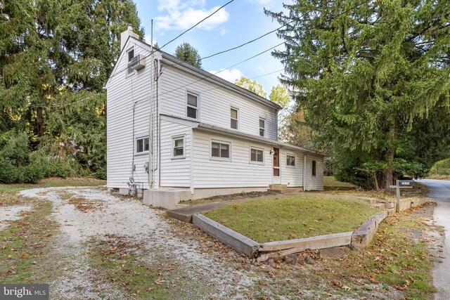 rear view of house featuring a yard