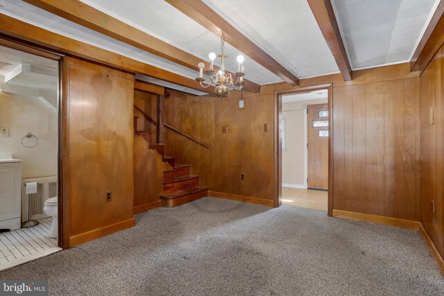 basement with light carpet, wood walls, and a chandelier