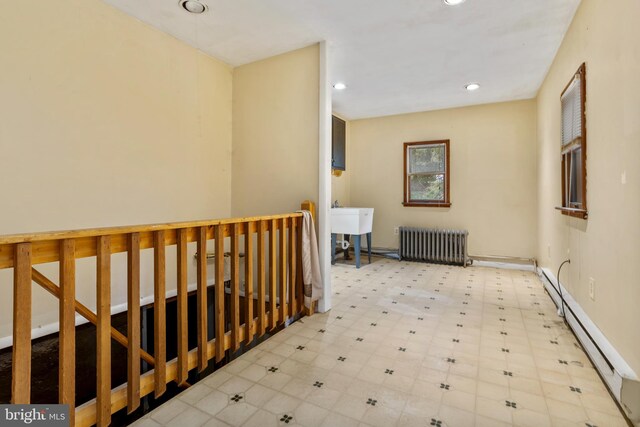 hallway featuring radiator and a baseboard radiator