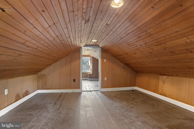 additional living space featuring wooden ceiling, vaulted ceiling, hardwood / wood-style flooring, and wooden walls