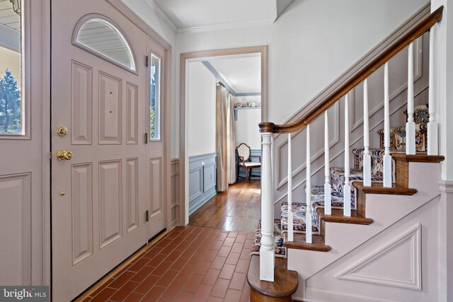 entrance foyer featuring ornamental molding and a healthy amount of sunlight