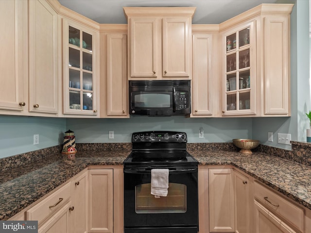 kitchen with light brown cabinetry, dark stone counters, and black appliances