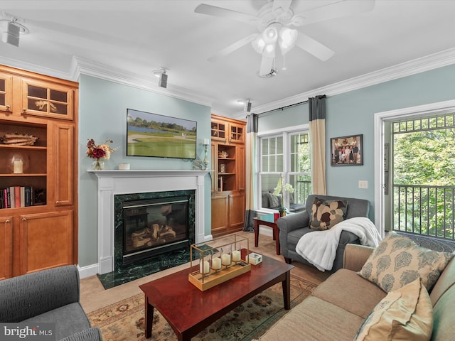 tiled living room featuring ornamental molding, a high end fireplace, and ceiling fan