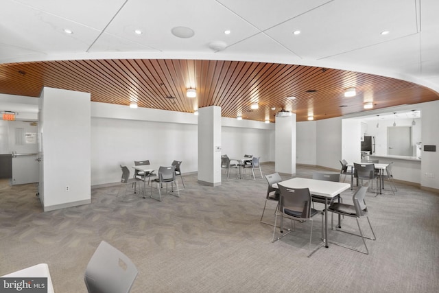 carpeted dining area with wooden ceiling