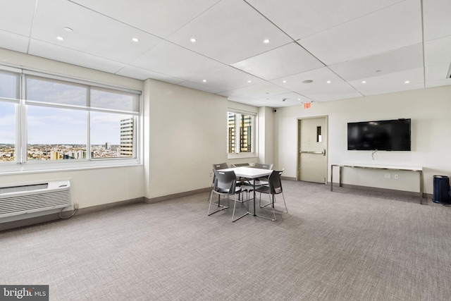 dining room featuring an AC wall unit and light colored carpet