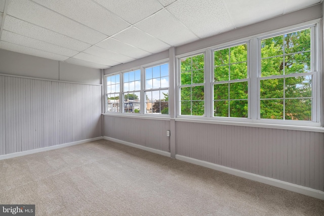 unfurnished sunroom featuring a drop ceiling