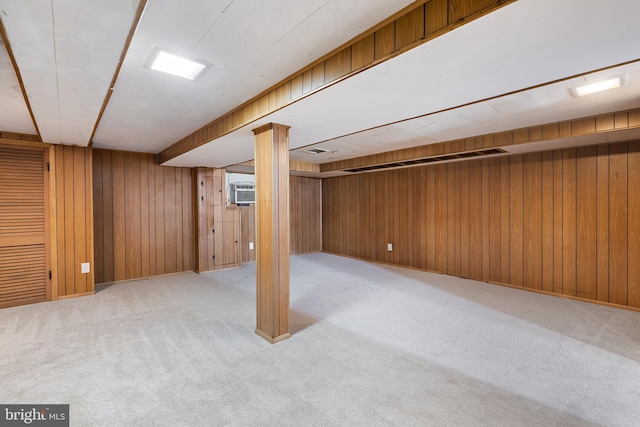 basement with light colored carpet, wood walls, and a wall mounted AC