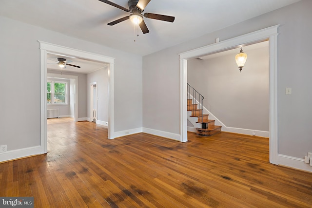 empty room with ceiling fan, hardwood / wood-style flooring, and radiator heating unit