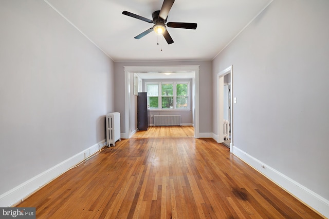 spare room featuring ceiling fan, crown molding, light hardwood / wood-style floors, and radiator heating unit