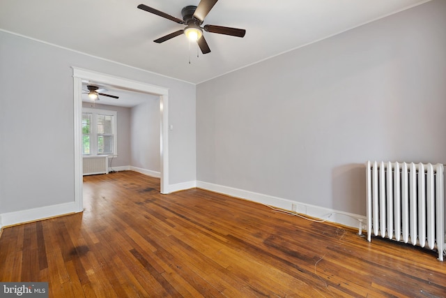 unfurnished room featuring hardwood / wood-style flooring, ceiling fan, and radiator