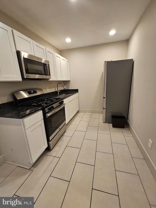 kitchen featuring light tile patterned flooring, white cabinetry, sink, and stainless steel appliances