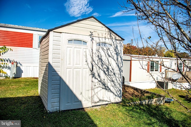 view of outbuilding featuring central AC and a yard