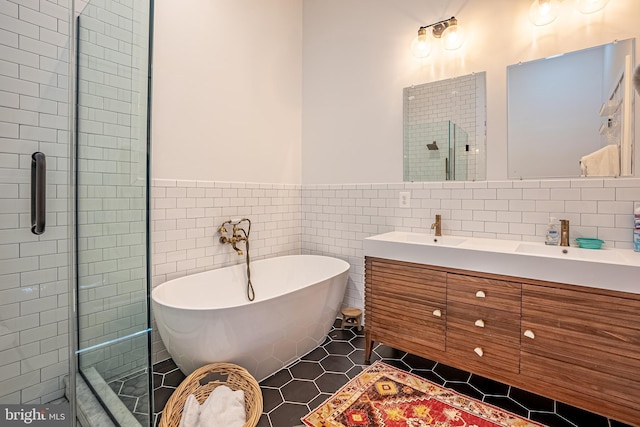 bathroom featuring tile walls, vanity, and independent shower and bath