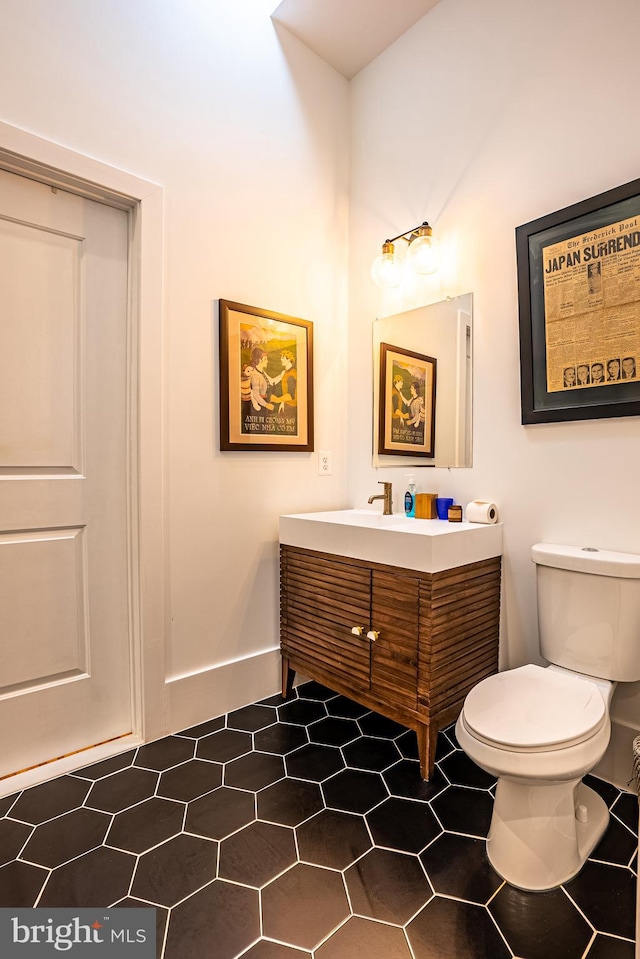 bathroom featuring vanity, tile patterned flooring, and toilet