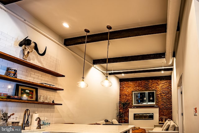 kitchen featuring pendant lighting, backsplash, and beamed ceiling