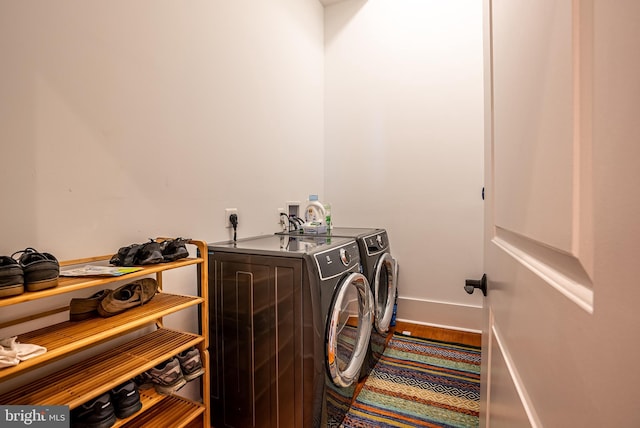 laundry room with separate washer and dryer and hardwood / wood-style flooring