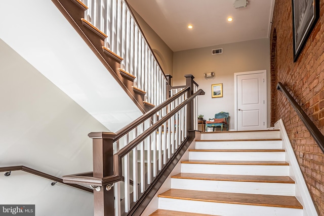 stairs with brick wall and a high ceiling