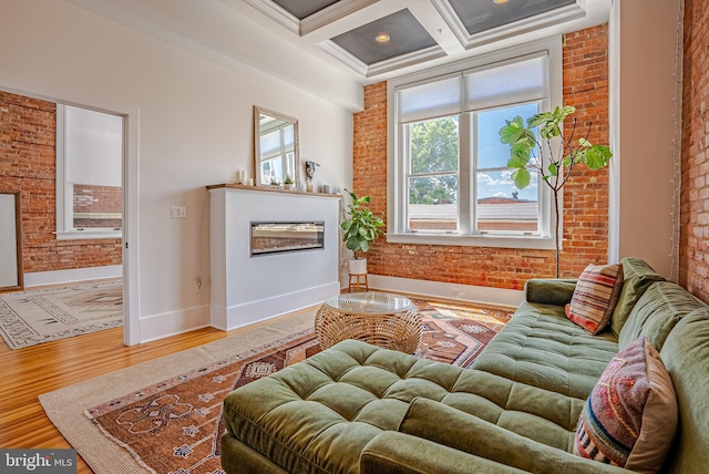 living room with beam ceiling, ornamental molding, brick wall, coffered ceiling, and hardwood / wood-style floors