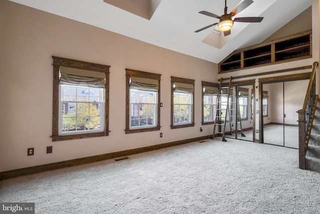 carpeted spare room with ceiling fan and vaulted ceiling