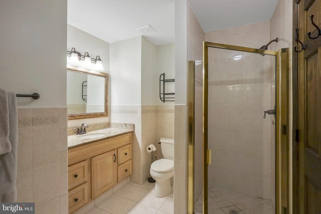 bathroom featuring vanity, an enclosed shower, tile patterned floors, tile walls, and toilet