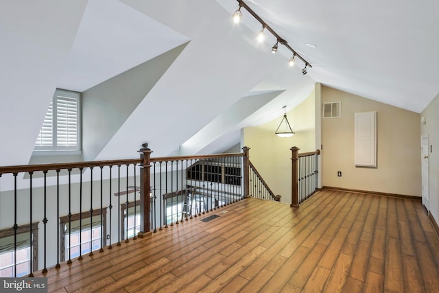 additional living space with wood-type flooring and vaulted ceiling